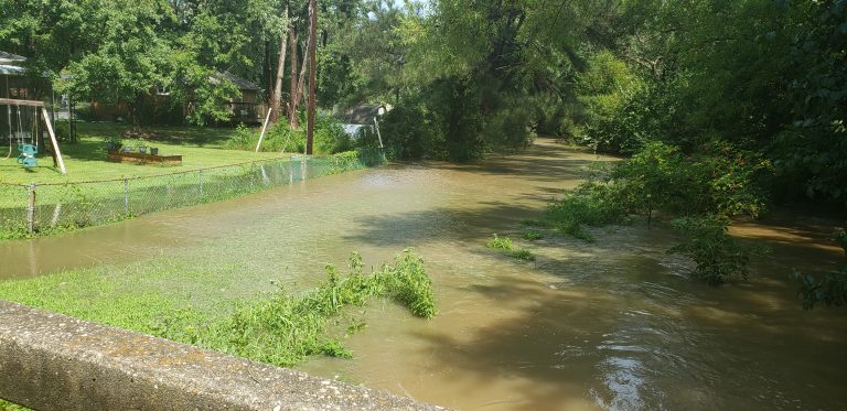 Flooded river behind a home.