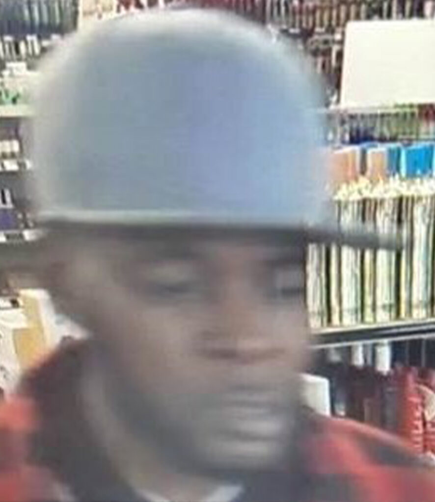 A close up surveillance photo of a man wearing a grey hat.