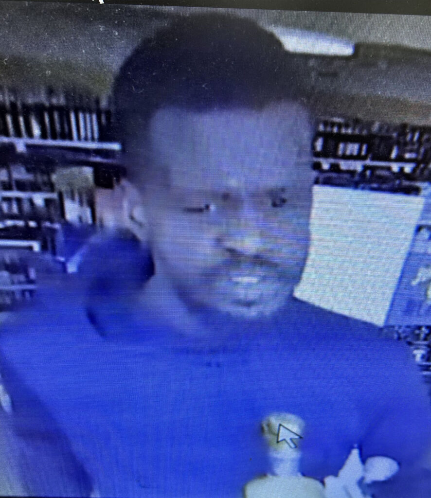 A screenshot of a man inside an ABC store who is wanted in a police investigation.