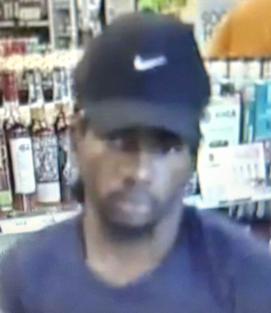 A person wearing a hat with a logo on it in an ABC Store.