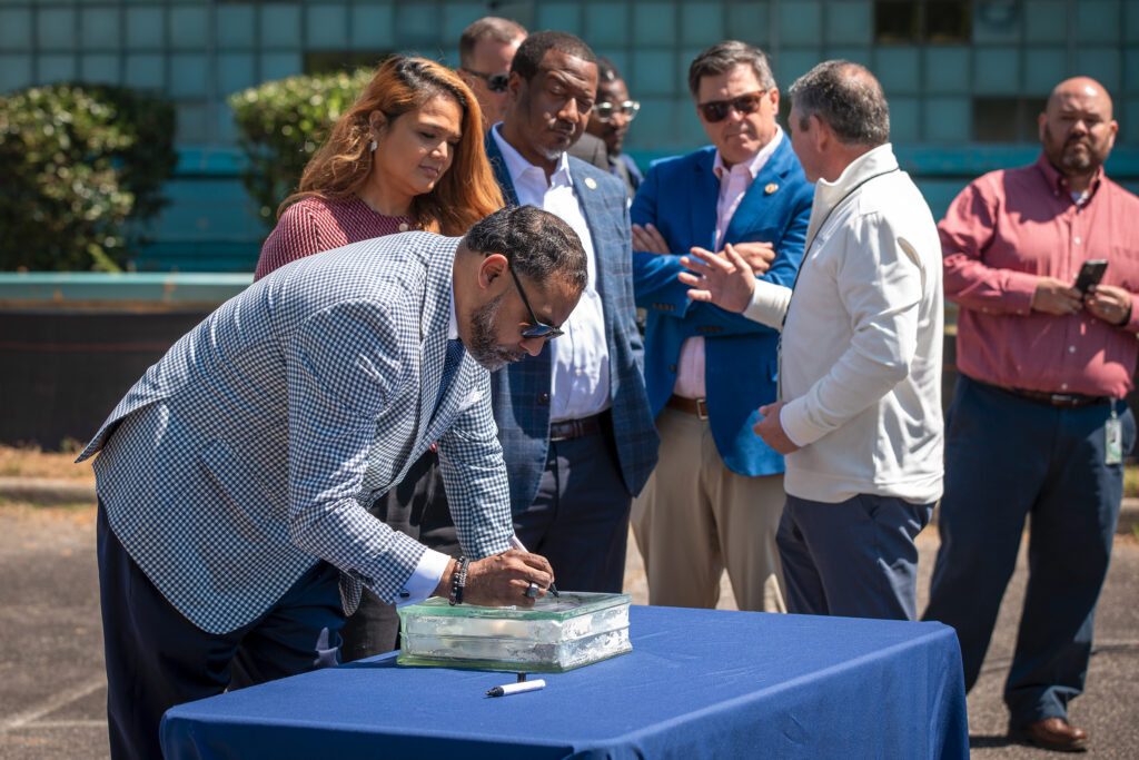 An official signs a glass block.