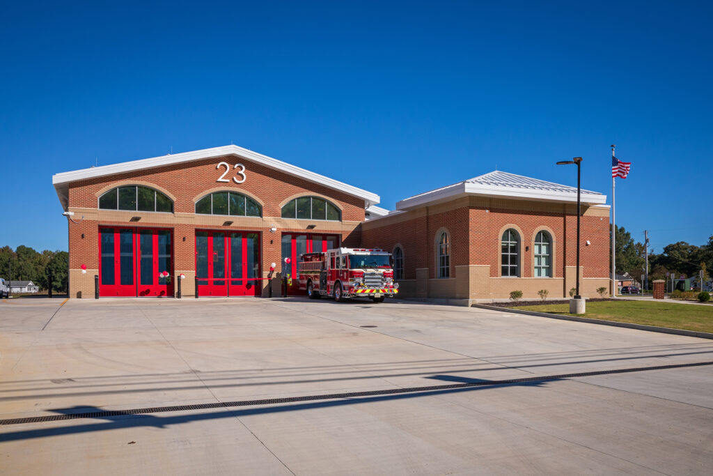 Exterior of Firehouse 23 with fire engine parked in front of a bay door.