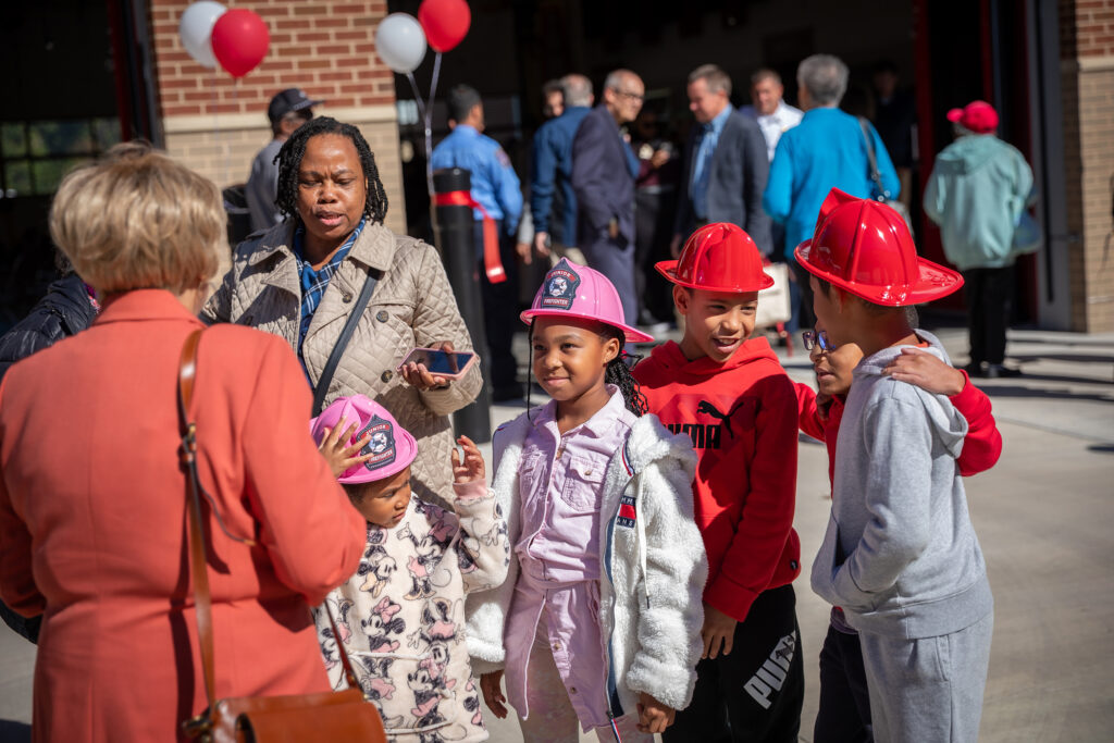 Children wear fire helmets at the opening of Firehouse 23.