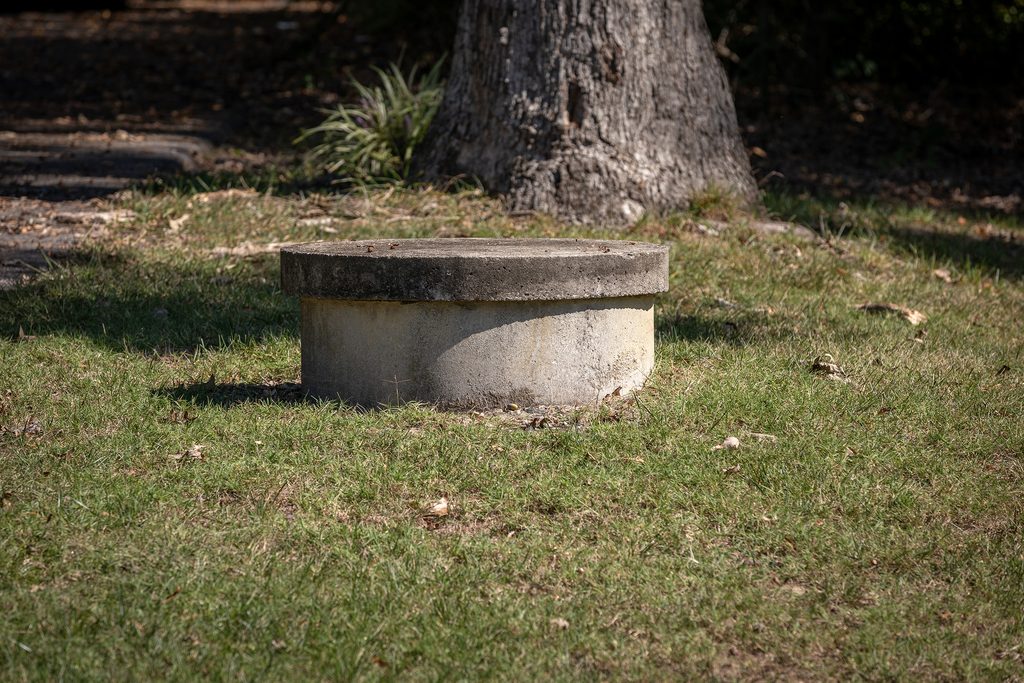 Private concrete well in a residential yard.