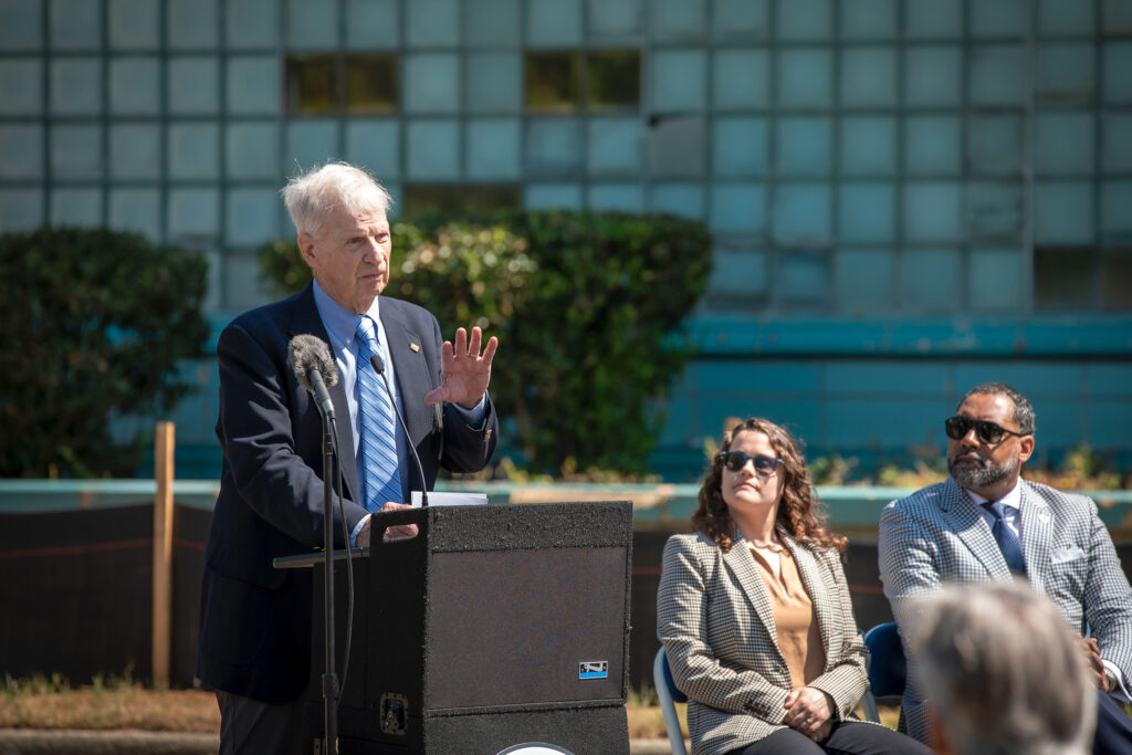 A speaker at a lectern at an outdoor event.