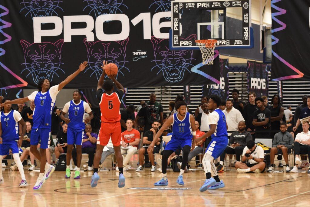 A basketball player shoots the ball while surrounded by defenders during the NXTPRO16 PUMA 2025 Pro-League Finals at the Henrico Sports & Events Center in July 2025.