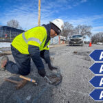 Utility worker working on a water valve with four sets of AAA.