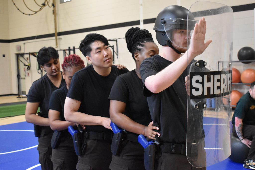 Men and women in black tshirt and safety shield