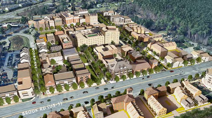 Aerial view of a suburban development plan featuring a grid layout with streets, parking areas, and multiple buildings in varying sizes. The main road is labeled "Brook Rd (US 1)." Surrounding areas include greenery and existing infrastructure. Trees line the streets, providing a sense of organization and greenery.