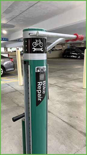 A bike repair station next to a parking deck.