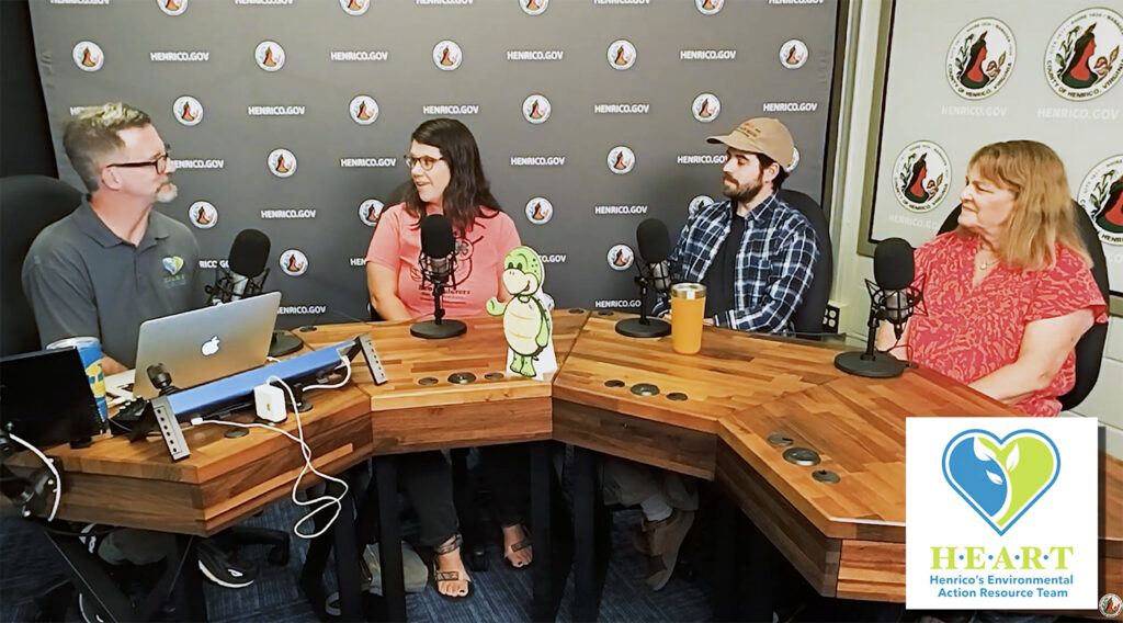 Four people on the set of a HEART podcast talking to each other.