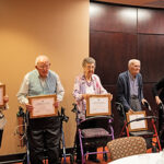 5 centenarians holding certificates of acknowledgement from the county.