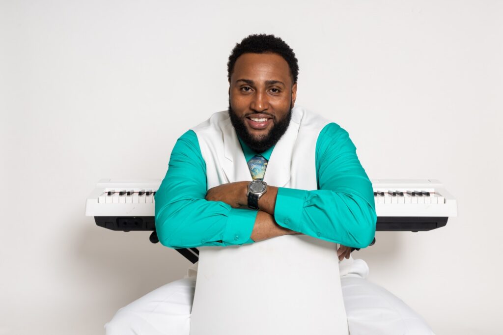 Musician Chan Hall sitting in front of a piano.