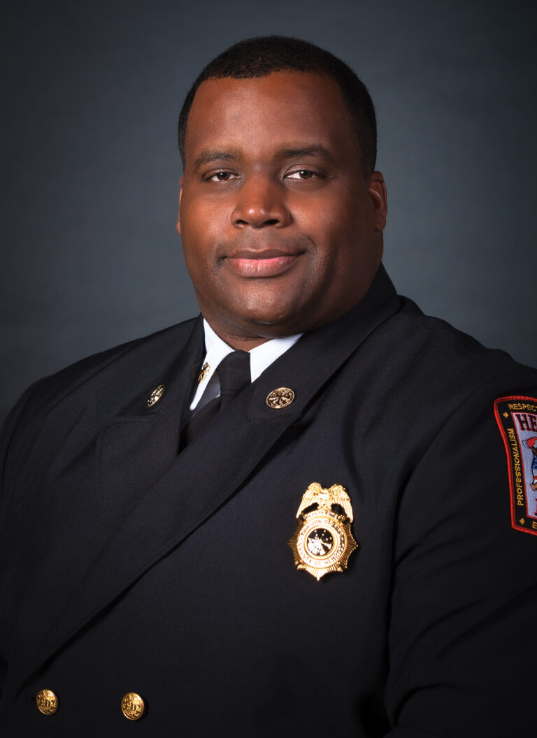 Formal portrait of Douglas Clevert in Class A Fire uniform with badge displayed.