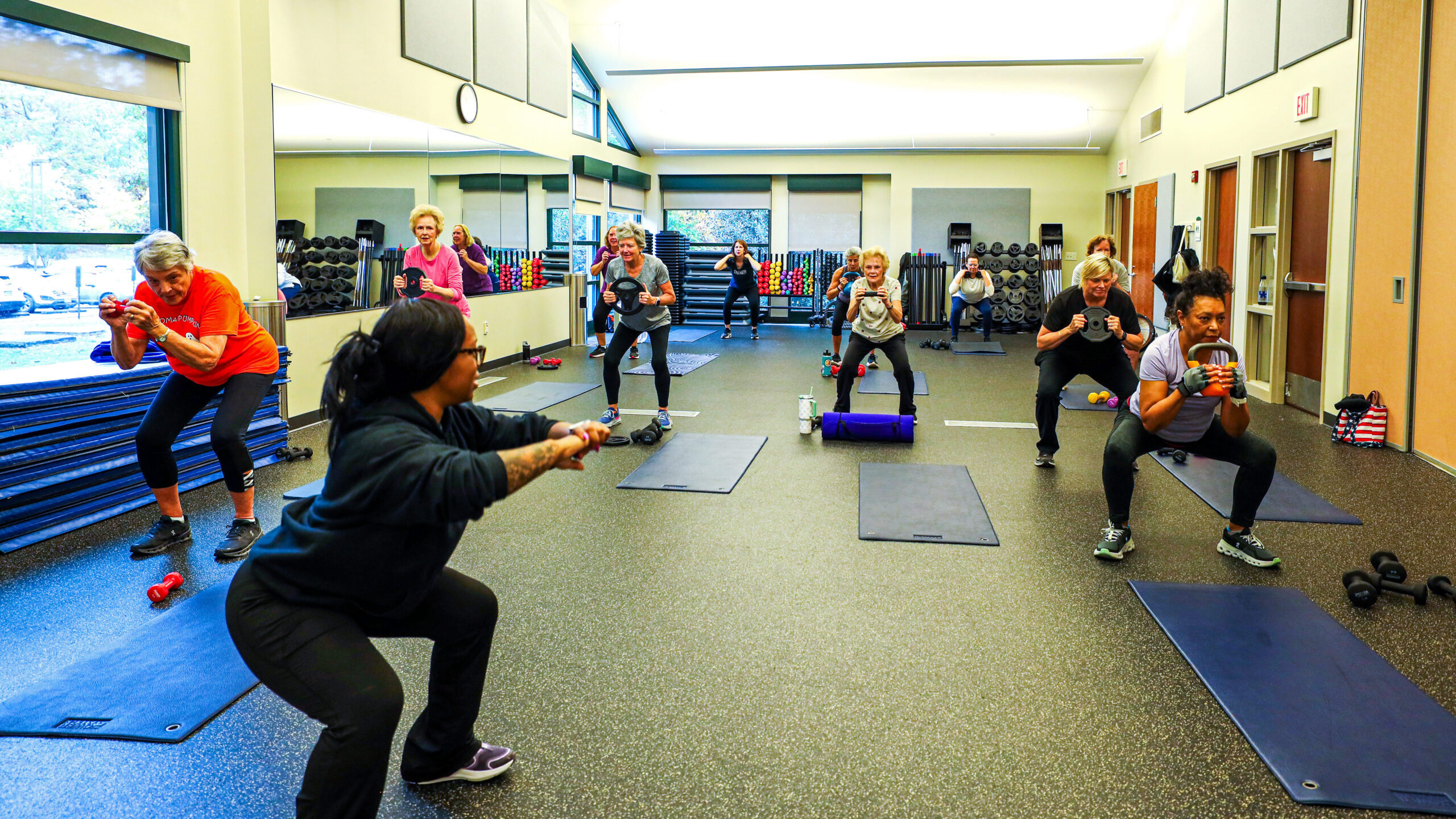 Core and Kettlebells class exercising at Deep Run Recreation Center. Instructor is giving directions and the class is following along. 