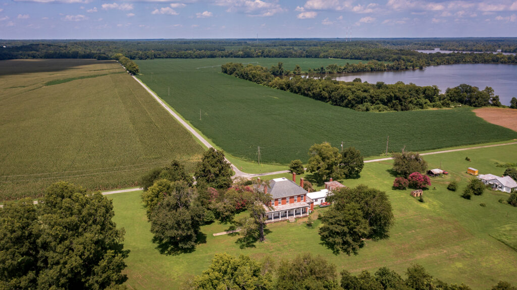 Aerial view of a home and fields along a river.