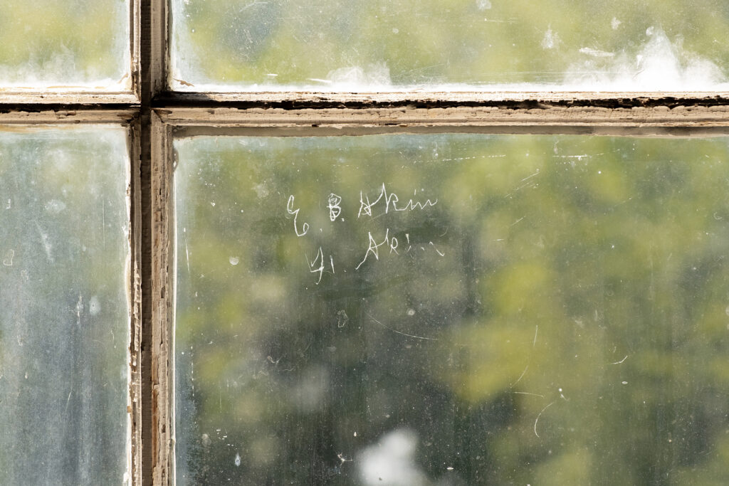 E.B. Akins is etched into a window's glass.