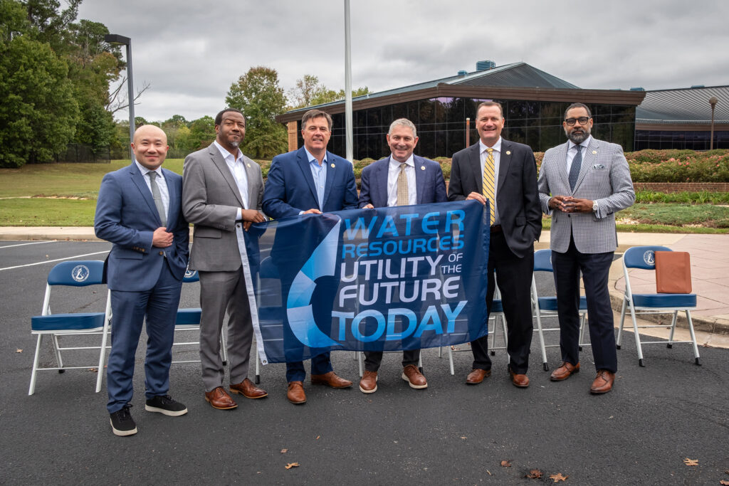 Henrico officials holding flag that reads, Water Resources Utilities of the Future Today.