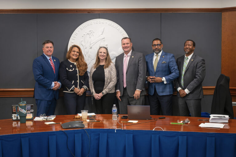 Sarah Gray poses with members of the Board of Supervisors in front of the county seal at the work session where she was recognized for her service to the county.