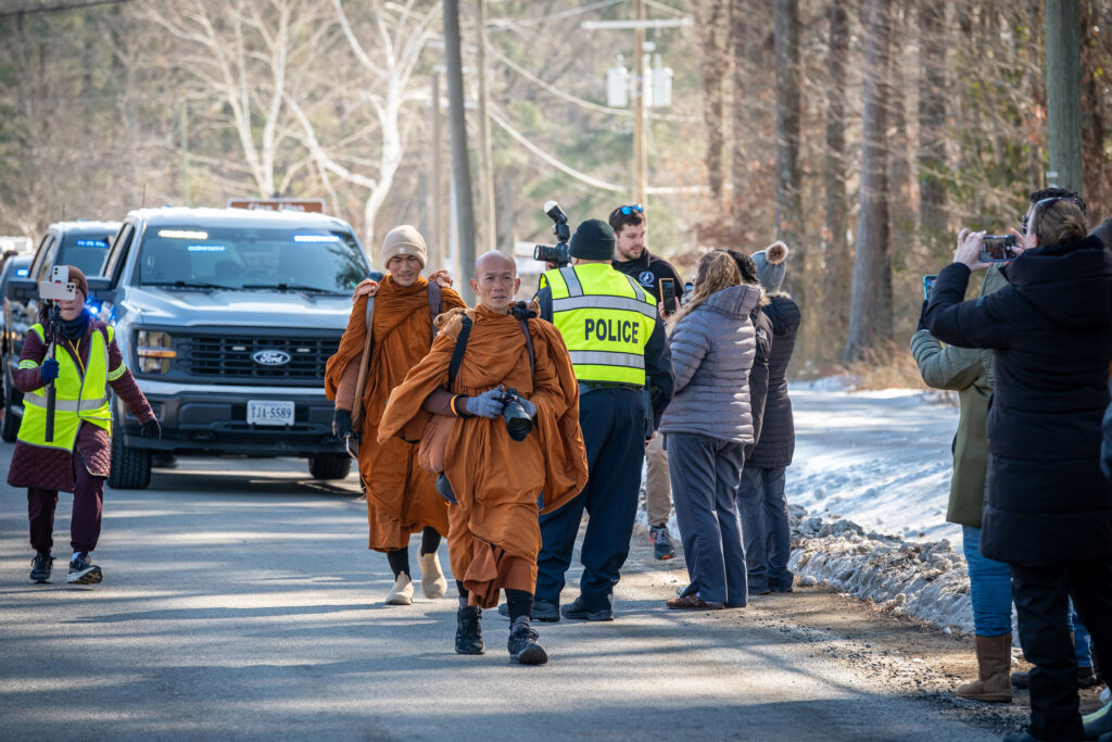 Monks are escorted by police to walk safely.