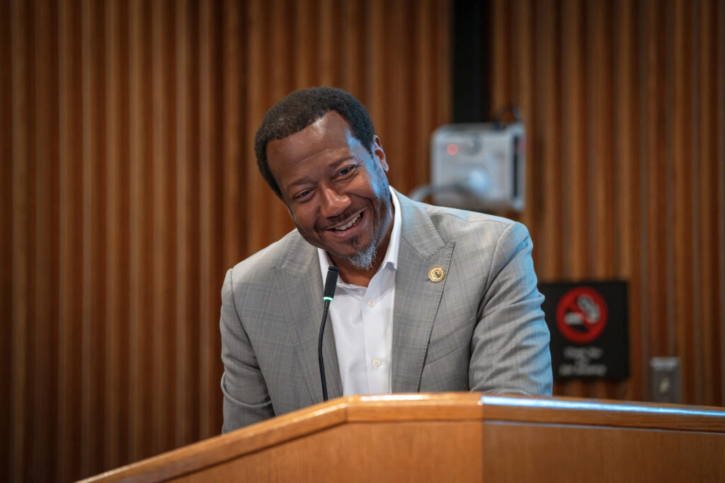 Supervisor Tyrone Nelson smiles at a meeting for Student Government Day.