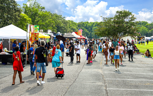 Picture of food vendors at Juneteenth and people walking around.