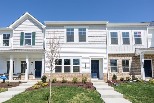 White and brick townhomes with manicured lawns.