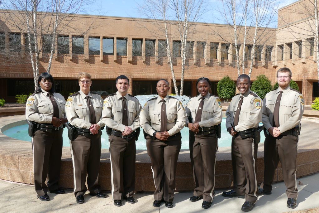 Group of men and women in uniform standing in front of building