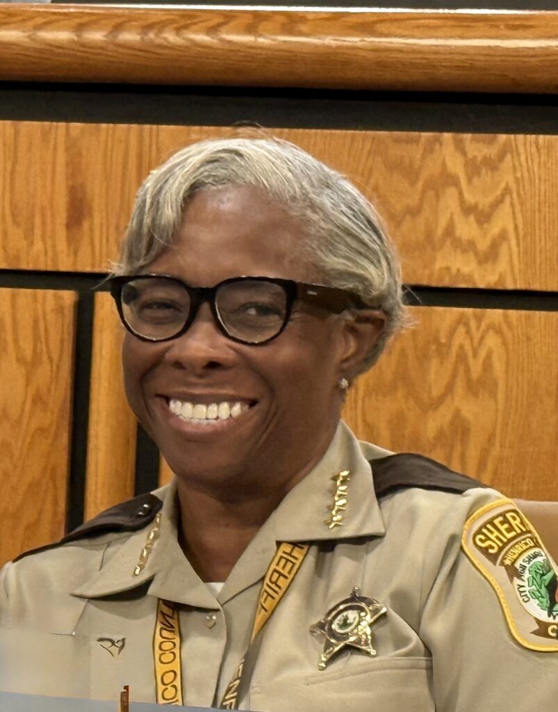 Sheriff Alisa Gregory smiles at a Board of Supervisors meeting.