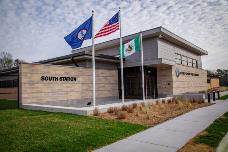 a sand colored-building with flags at the new police station