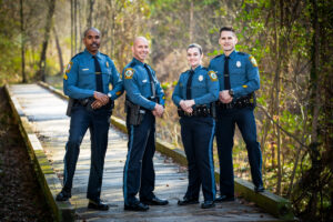 Group of Henrico County Police Officers in Uniform on a path in the woods.