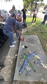 A man & woman spray painting a template