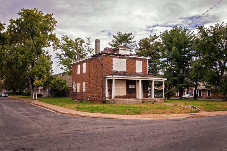 Brick house with boarded up windows