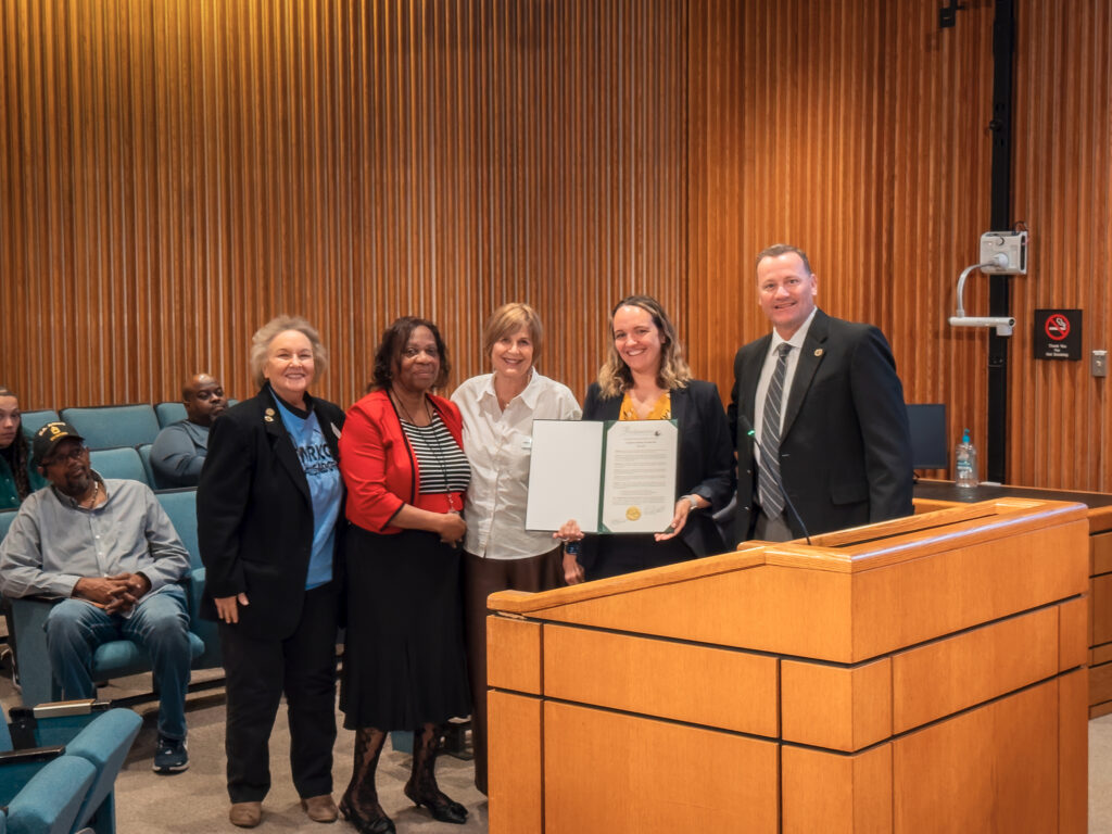Amy Strite, Ashlee Giles and other employees accept the Older Americans Month proclamation at the board meeting.