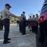 As part of an honor guard training, participants carry a casket.