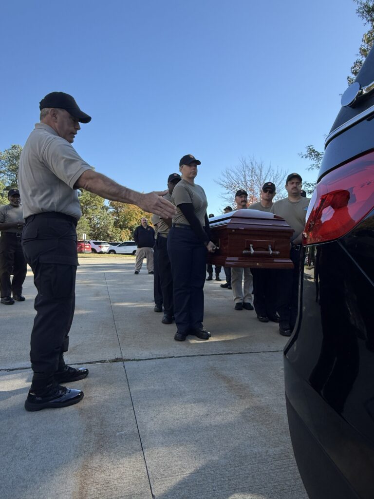 As part of an honor guard training, participants carry a casket.
