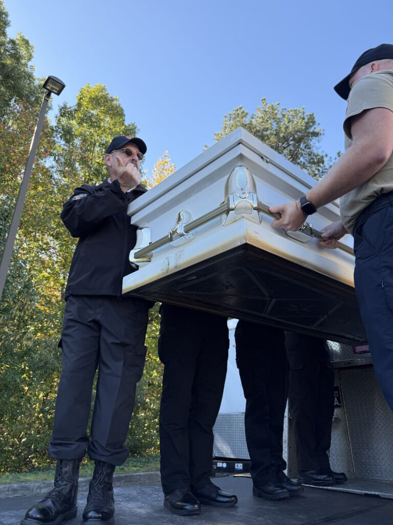 As part of an honor guard training, participants carry a casket.