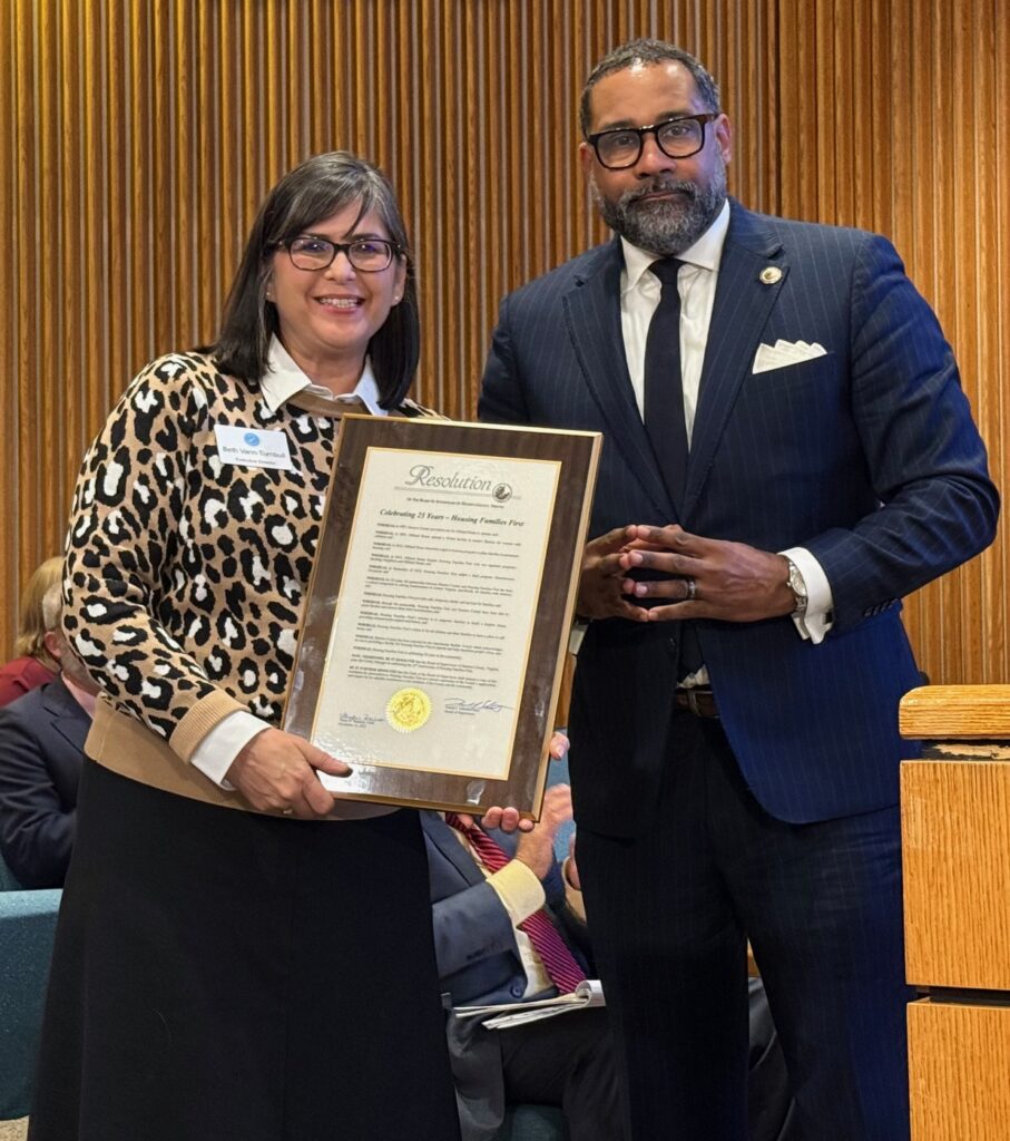 Officials presents framed resolution to Beth Vann-Turnbull, executive director of Housing Families First.
