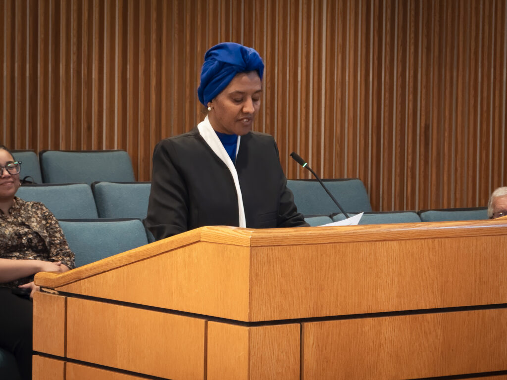 Elham Khairi, multicultural liaison, speaks at a lectern.