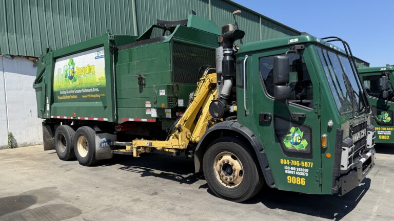 A green recycling truck with the logo and branding of TFC Recycling is parked in a lot. The truck has contact information and the number 9086 visible on it.