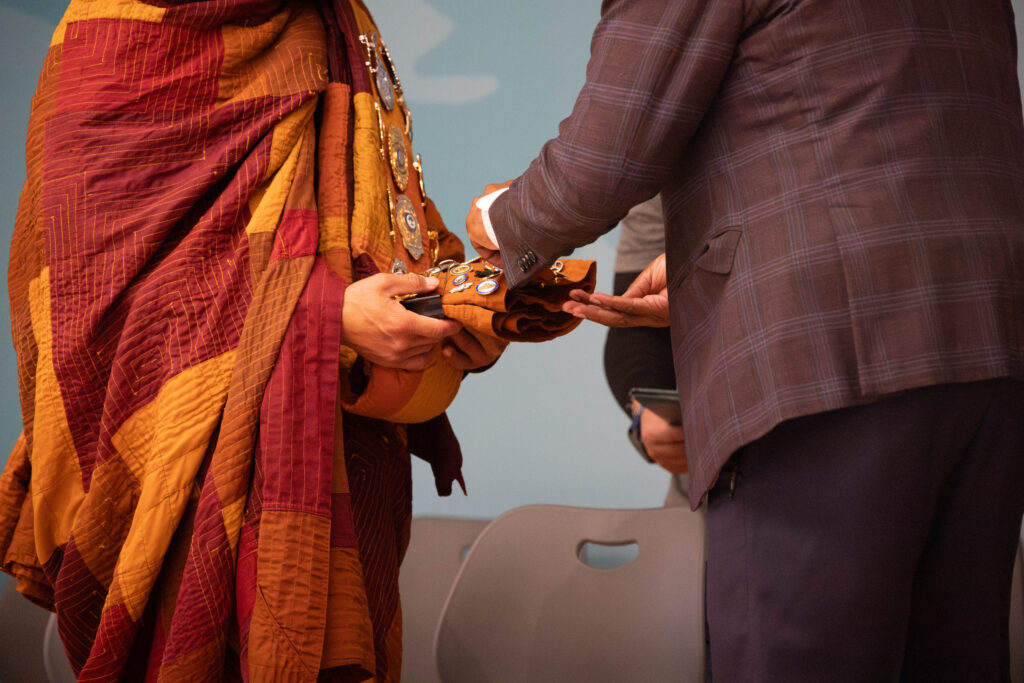 A Henrico County supervisor places a pin on a monk's robe.