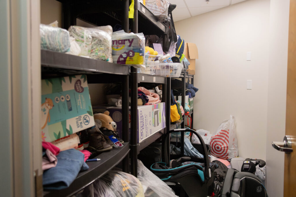 A closet has floor-to-ceiling shelves packed with supplies for young children.