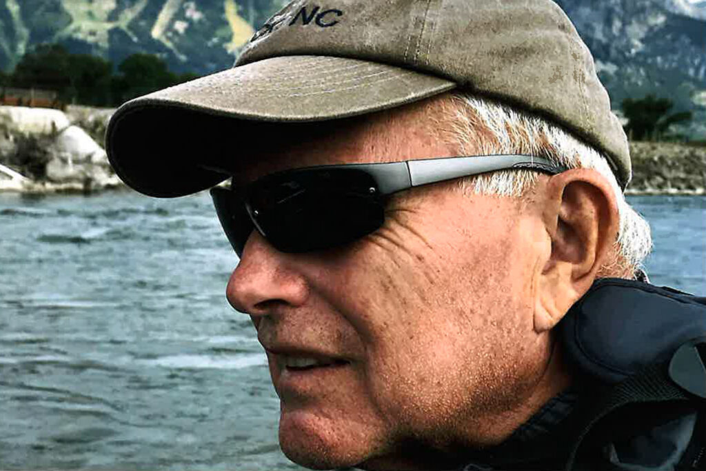 A man watches a river flow in front of him.
