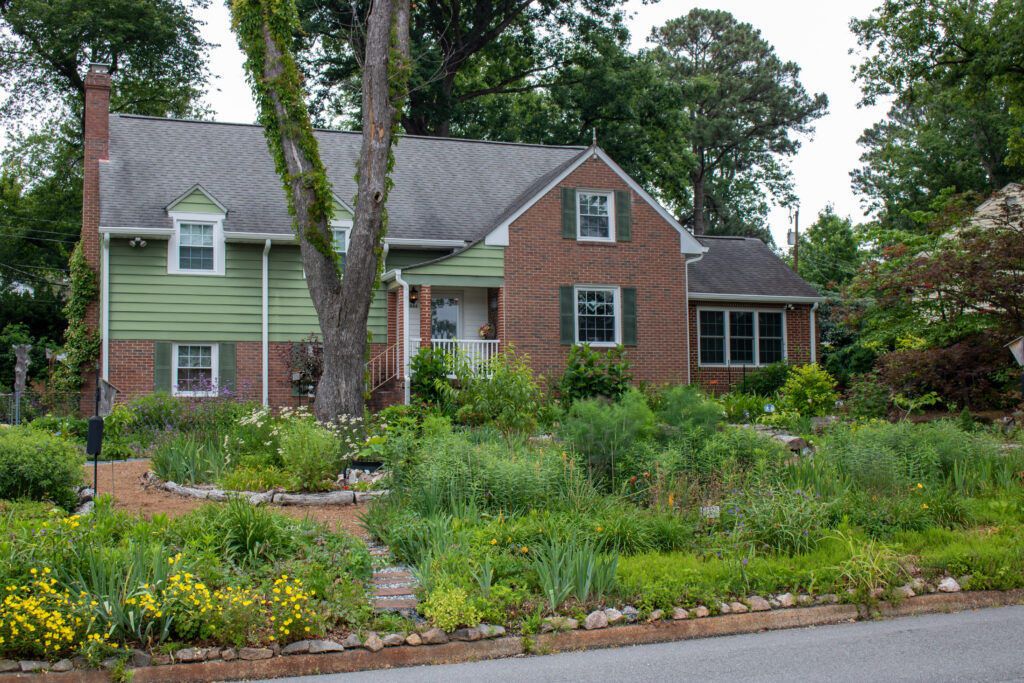 photo of house with a front yard that is overflowing with thriving plants