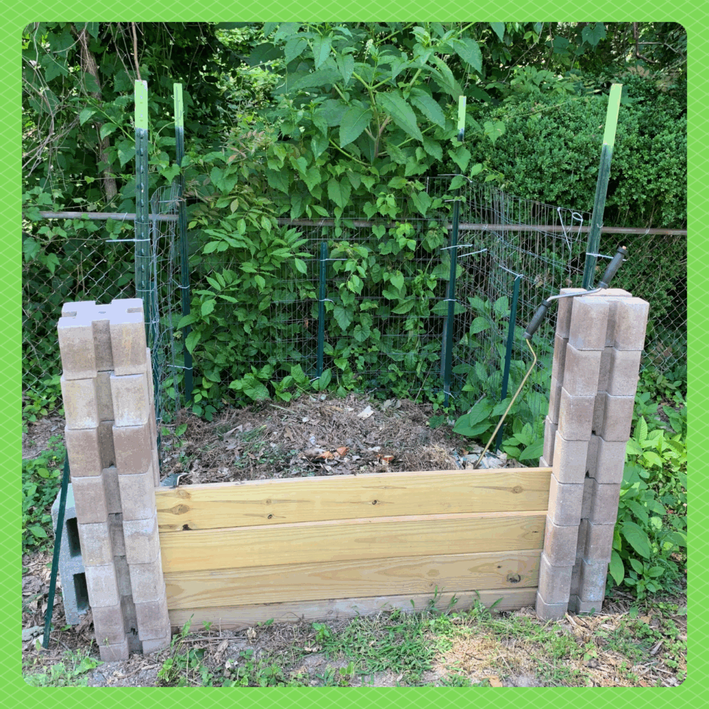 Photo of a compost pile contained with a wired fence and wooden planks.