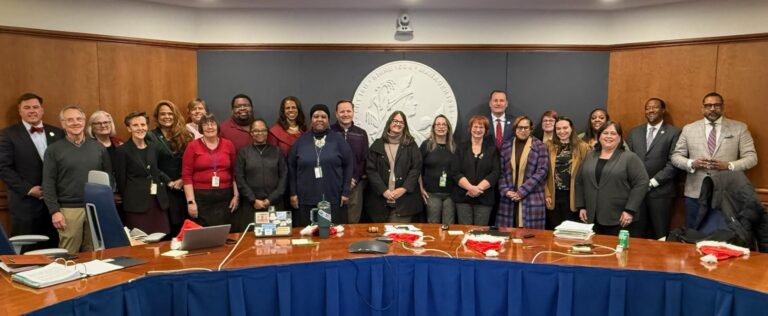 Staff of Henrico Area Mental Health & Developmental Services stand for a photo with the Board of Supervisors in a large meeting room.