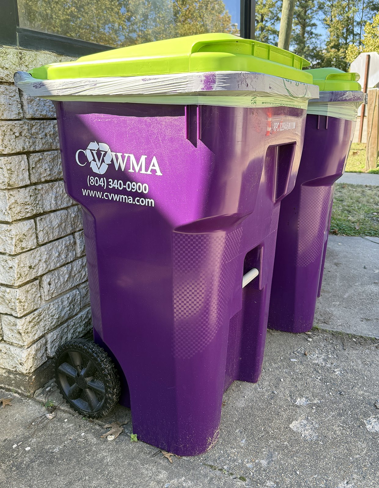 Purple composting cart on wheels with yellow-green top.