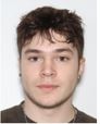 Image shows a white male, with short brown hair and earrings in his ears.