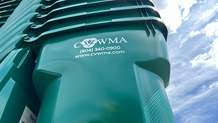 tall stacks of green recycle bins with white clouds & blue sky