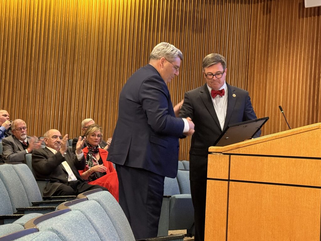 A man shakes hands with Supervisor Rogish.